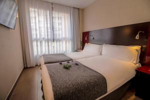 a hotel room with a large bed and a large window at SM Hotel Teatre Auditori in Barcelona
