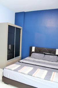 a blue bedroom with a bed and a window at Teluk Kemang Homestay - Laguna Resort in Port Dickson