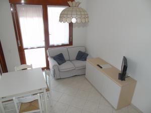 a living room with a couch and a table at Condominio Imperiale in Lignano Sabbiadoro