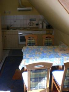 cocina con mesa, sillas y mesa en Letztes-Haus-vorm-Wasser-1, en Strukkamp auf Fehmarn