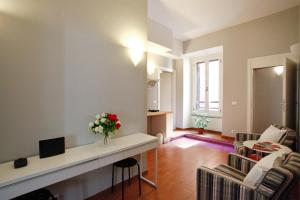 una sala de estar con un jarrón de flores en un mostrador en Clemy In Rome, en Roma