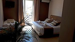 a bedroom with two beds and a window at Hotel Restaurant L'Escale in Le Grau-dʼAgde