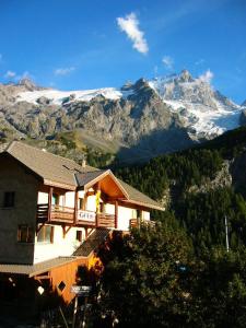 una casa en una colina con una montaña cubierta de nieve en Gîte Le Rocher, en La Grave