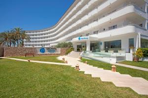 a large building with a grassy yard in front of it at Grupotel Maritimo in Port d'Alcudia