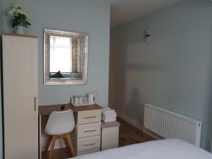 a bedroom with a desk and a chair and a window at Lynch's in Kilkee