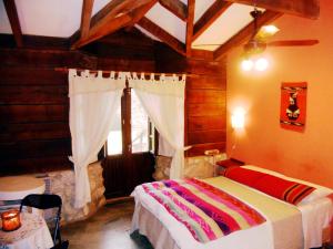 a bedroom with a bed in a room with a window at Posada La Ensenada in Villa Yacanto