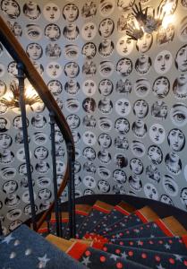 a wall with faces on the wall at Hôtel du Triangle d'Or - Proche Madeleine in Paris +70 photos
