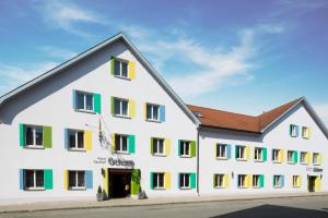 a large white building with colorful windows at Hotel Gasthof Ochsen in Kißlegg