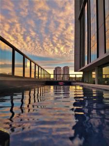 a building with a pool of water in front of it at Wyndham Garden Ribeirão Preto Convention in Ribeirão Preto