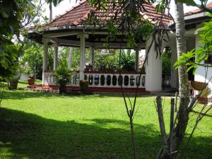 a gazebo in a yard with green grass at Top of the Hill Guesthouse in Weligama