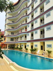 a hotel with a swimming pool in front of a building at Smile Residence in Rawai Beach
