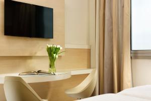 a room with a table with a vase of flowers at Hotel La Favorita in Mantova