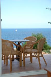 eine Gruppe von Stühlen und einem Tisch auf einer Terrasse mit Meerblick in der Unterkunft Residencial Playa Mar in Cala Mendia