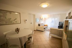 een woonkamer met een witte tafel en een bank bij Relaxing and Comforting in Olbia