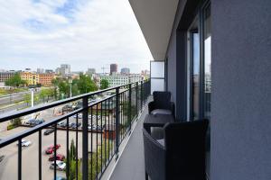 a balcony with chairs and a view of a city at Expo Home Apartment by PinPoint in Łódź