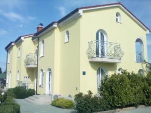 a large yellow building with balconies on it at Ana Rooms in Krk