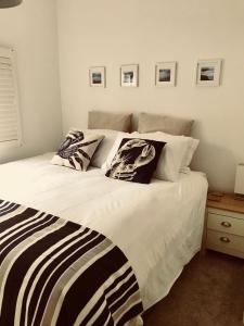 - une chambre avec un grand lit blanc et des oreillers dans l'établissement Eden Cottage, à Frodsham