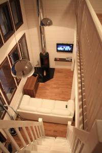 a living room with a white couch and a television at Findomik Cottages in Hankasalmi