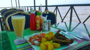 a table with a plate of food and a glass of beer at Milimani Beach Resort in Kisumu
