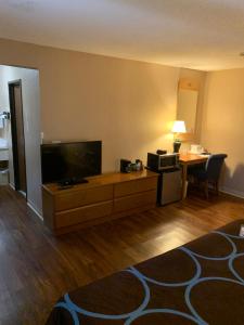 a living room with a flat screen tv and a table at Super 8 by Wyndham Kingston in Kingston