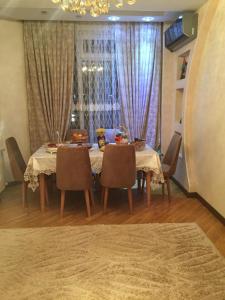 uma sala de jantar com uma mesa e cadeiras e uma janela em House Impulse Xazar em Baku