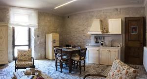 cocina con mesa, sillas y nevera en Agriturismo La Pieve, en Colle Val D'Elsa