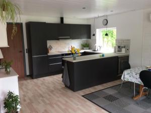 a kitchen with black cabinets and a white counter top at Hummingen Strand 21 in Dannemare