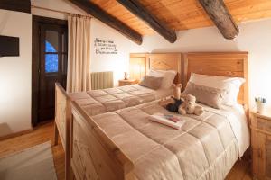 a bedroom with a large bed with a teddy bear on it at Albergo Pa' Krhaizar in Sauris