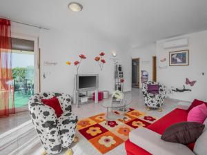 a living room with a couch and chairs and a tv at Apartment Daria by Interhome in Labin