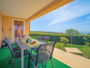 a table and chairs on a patio with a view of a vineyard at Apartment Daria by Interhome in Labin