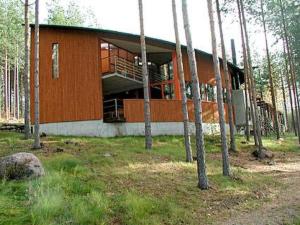a building in the middle of a forest with trees at Holiday Home Huvila hiljaisuus by Interhome in Okka