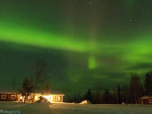 Eine Aurora am Himmel über einem Gebäude mit einer Person in der Unterkunft Holiday Home Levin revontulitaivas 1 by Interhome in Köngäs