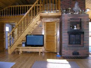 ein Wohnzimmer mit einem TV und einer Treppe in der Unterkunft Holiday Home Hirviharju by Interhome in Torsansalo