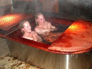 two women sitting in a bathtub with at Holiday Home Huvila hiljaisuus by Interhome in Okka