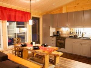 eine Küche mit Holztisch und ein Esszimmer in der Unterkunft Holiday Home Levin revontulitaivas 1 by Interhome in Köngäs