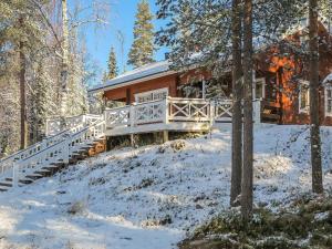 a house in the woods with snow on the ground at Holiday Home Tokkimus by Interhome in Luosto