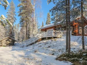 una cabaña de madera en el bosque en la nieve en Holiday Home Tokkimus by Interhome, en Luosto