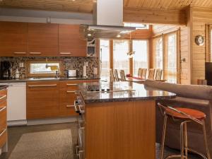 eine Küche mit Holzschränken und einer Arbeitsplatte in der Unterkunft Holiday Home Syvärinkulta b by Interhome in Tahkovuori