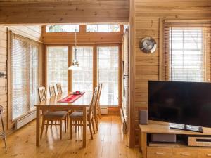 ein Esszimmer mit einem Tisch und einem TV in der Unterkunft Holiday Home Syvärinkulta b by Interhome in Tahkovuori