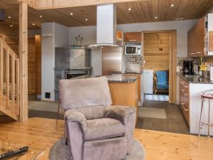 ein Wohnzimmer mit einem Stuhl und eine Küche in der Unterkunft Holiday Home Syvärinkulta b by Interhome in Tahkovuori