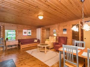 una sala de estar con paredes de madera y techo de madera. en Holiday Home Mäntyranta by Interhome, en Harjula