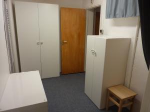 a room with a white refrigerator and a wooden door at Huddinge Studio with Private Entrance in Huddinge