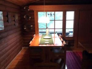 a dining room with a table with a lamp on it at Holiday Home Sokeelampi by Interhome in Matku +14 photos