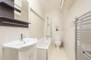 a bathroom with a sink, toilet and bathtub at Central London Rooms in London