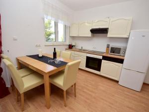 La cuisine est équipée d'une table, de chaises et d'un réfrigérateur. dans l'établissement Apartment Anđa-1 by Interhome, à Trogir