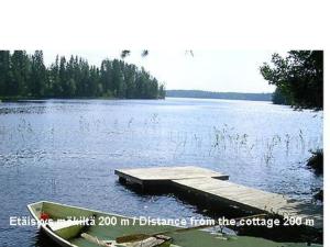 a dock in the middle of a lake with a boat at Holiday Home Suvikumpu by Interhome in Tuusmäki