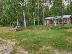 una cabaña de madera en el bosque con un columpio en Holiday Home Koivuranta by Interhome, en Oravi