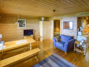 a living room with a blue couch and a wooden wall at Holiday Home Pajuranta by Interhome in Oravi