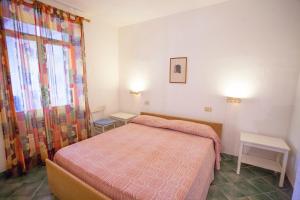 a small bedroom with a bed and a window at Appartamenti La Zanca in Zanca
