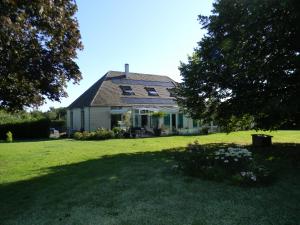 ein Haus mit einem großen Garten mit grünem Gras in der Unterkunft Maison Magdala in Fourmies